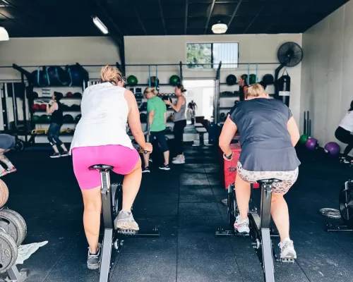 two women doing their stationary bike exercise