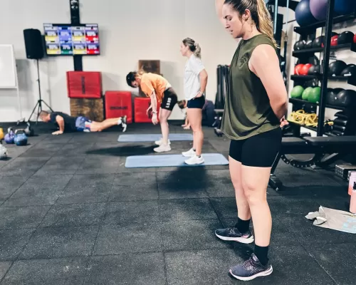 a woman doing her workout with other people at the background