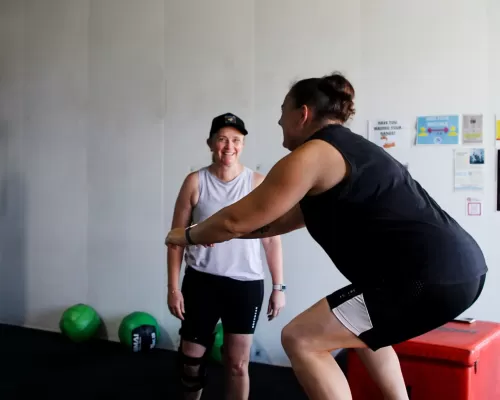 a woman doing her exercise with the guidance of a trainer