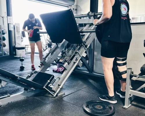 two girls setting up their weights at a  gym