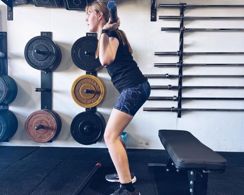 girl holding the bar doing squats