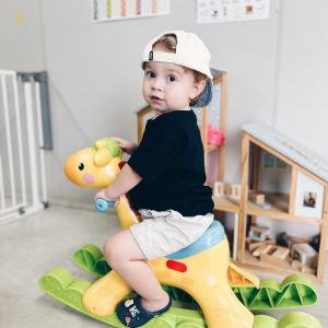A kid riding his rocking dinosaur toy