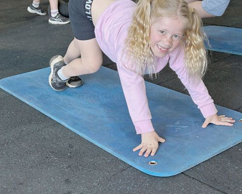 a kid on the mat doing stretching