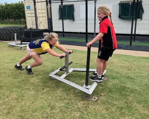 kid pushing equipment with one kid on it